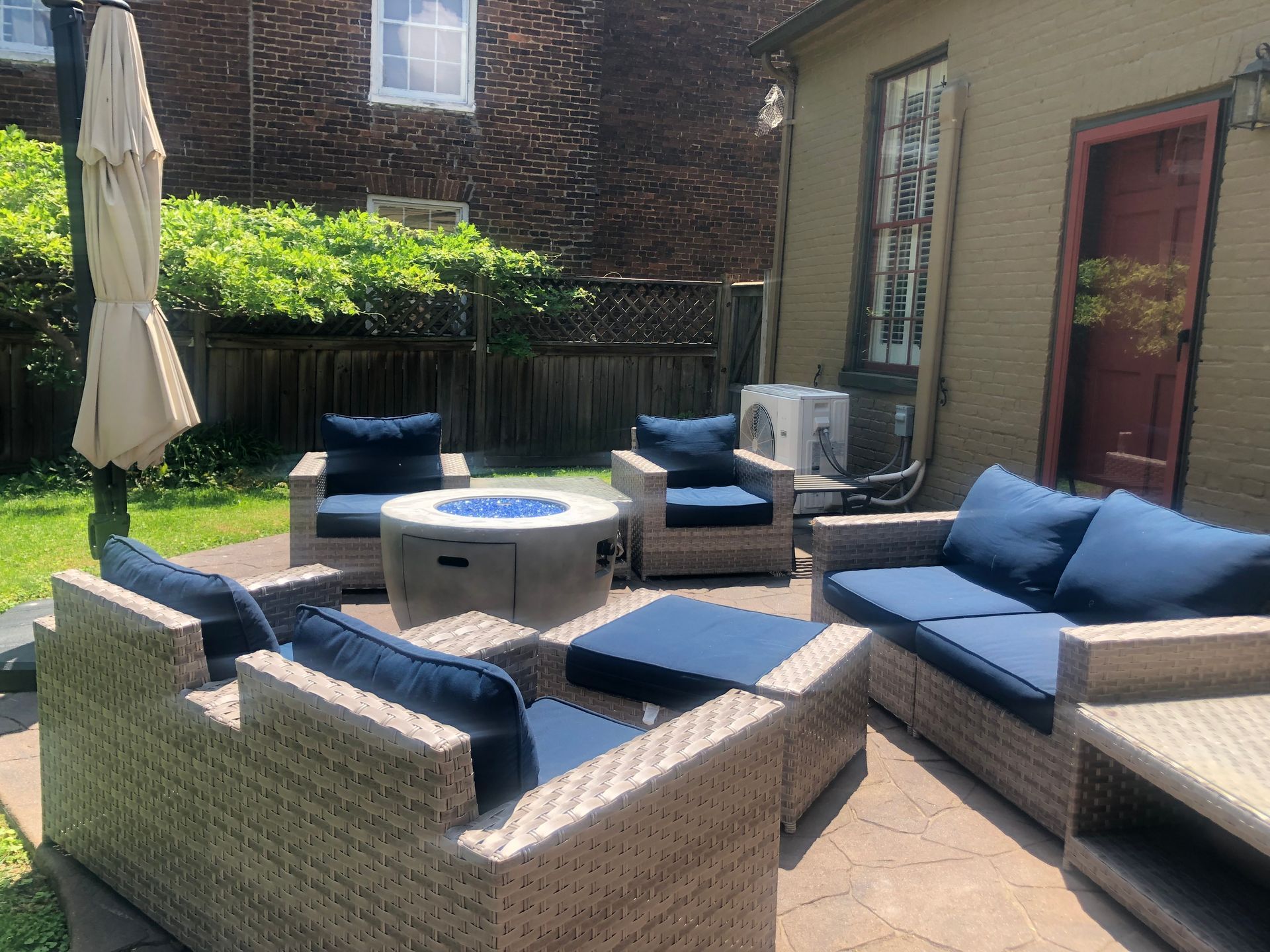 A patio with wicker furniture and a fire pit