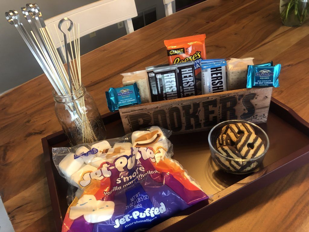 A wooden tray filled with snacks and a sign that says booker 's on it.