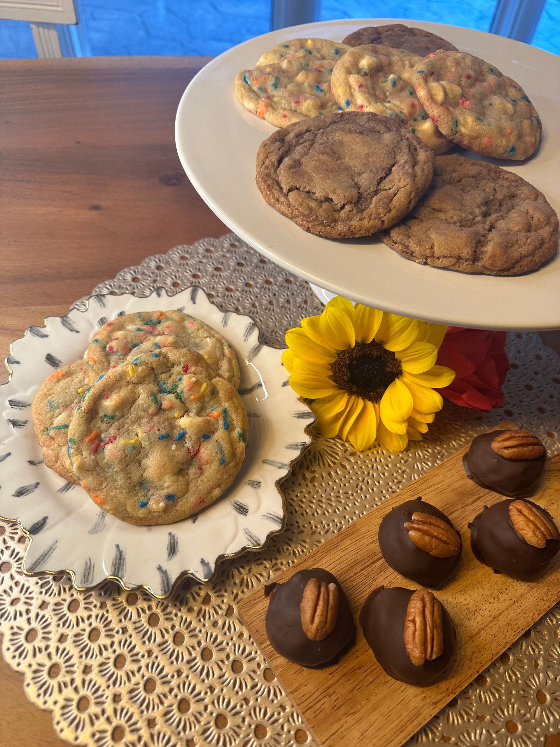 A table topped with plates of cookies and chocolates.