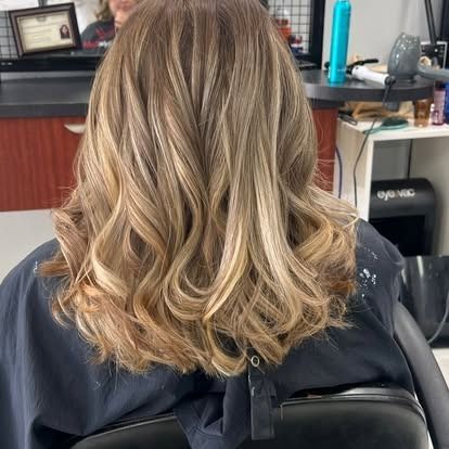 Hair with highlights and loose curls, styled at a salon.