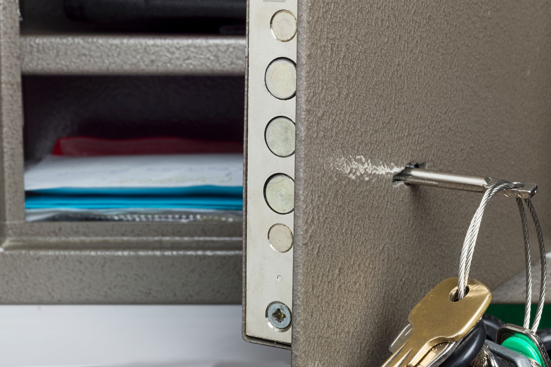 Open safe with keys hanging from the lock, showing papers inside a compartment