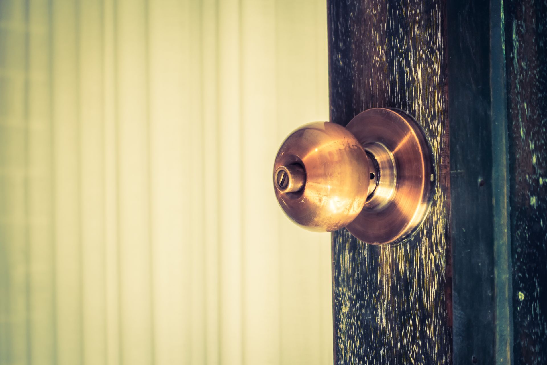 A close up of a door knob on a wooden door.