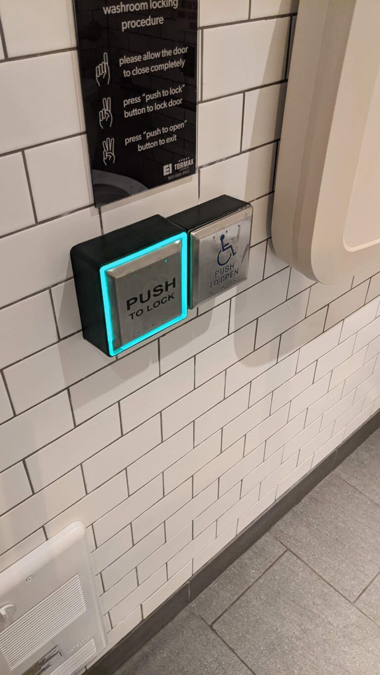 a bathroom with a sign on the wall that says push button .