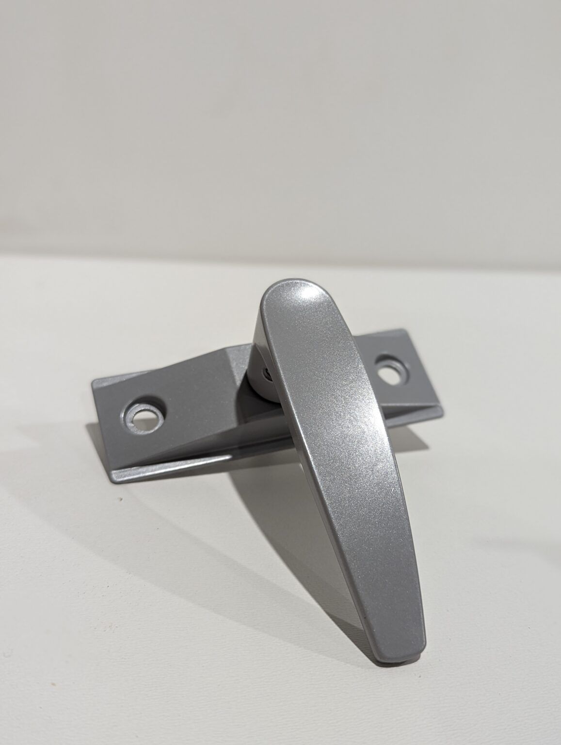 a close up of a metal handle on a white surface .