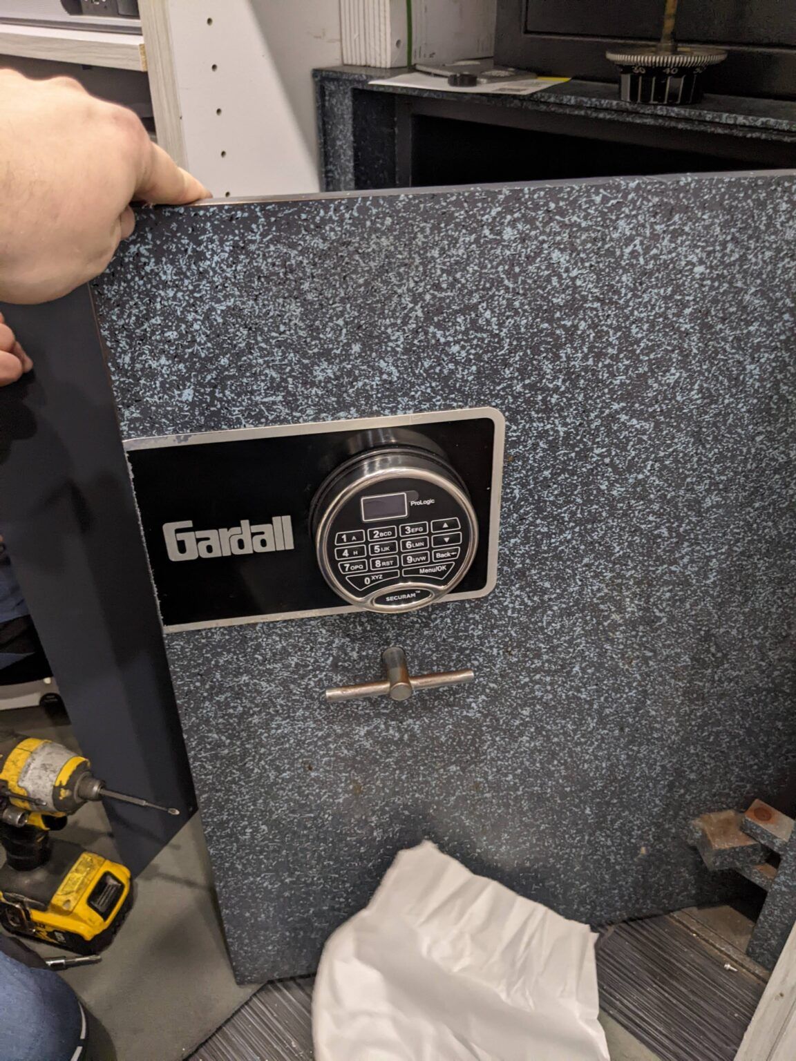 a person is opening a safe with a drill .