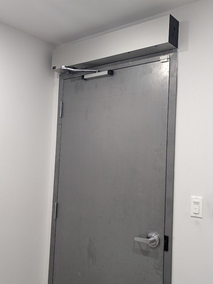 A gray door is hanging on a white wall in a room.