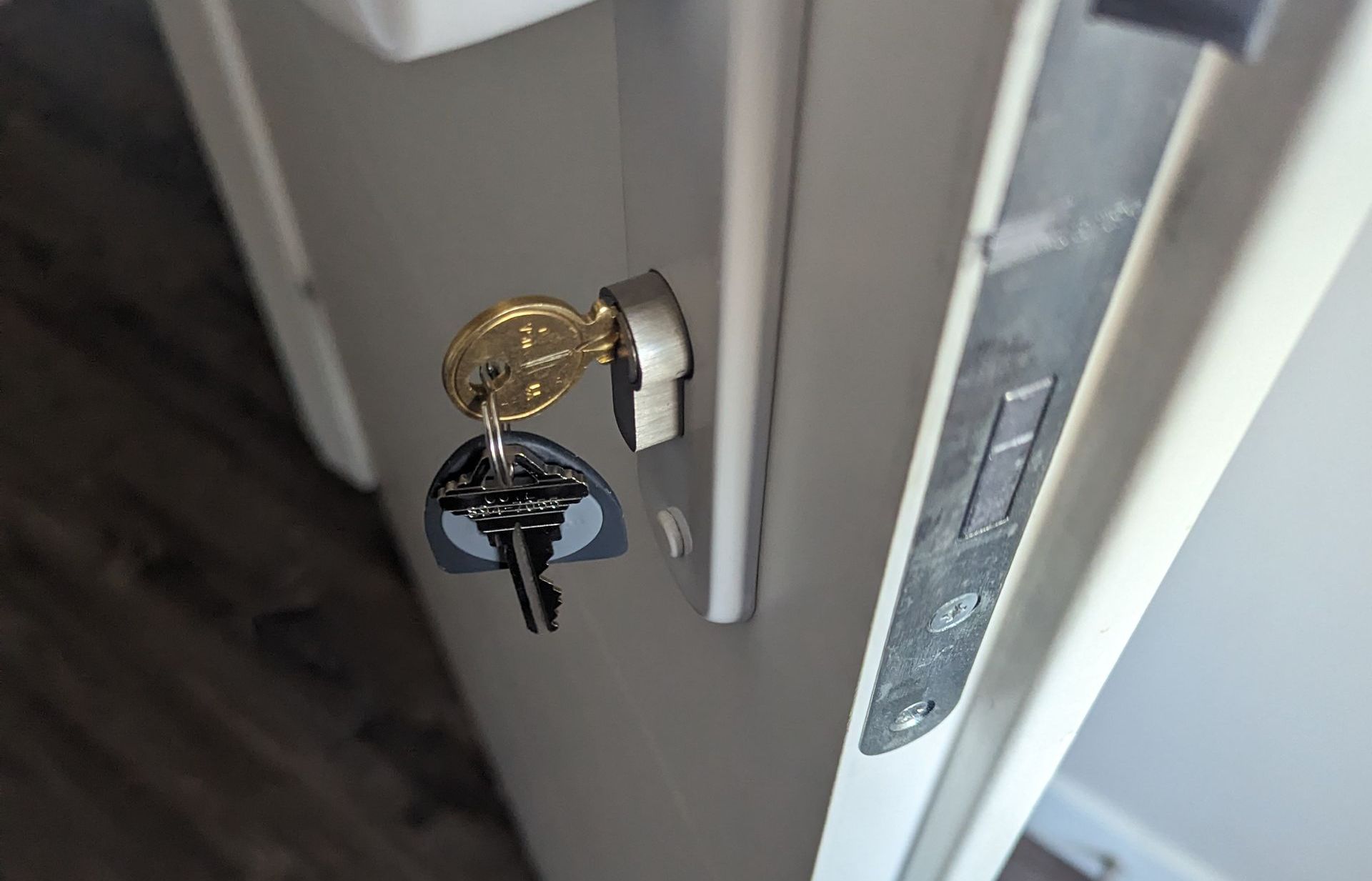 A close up of a door lock with two keys in it.