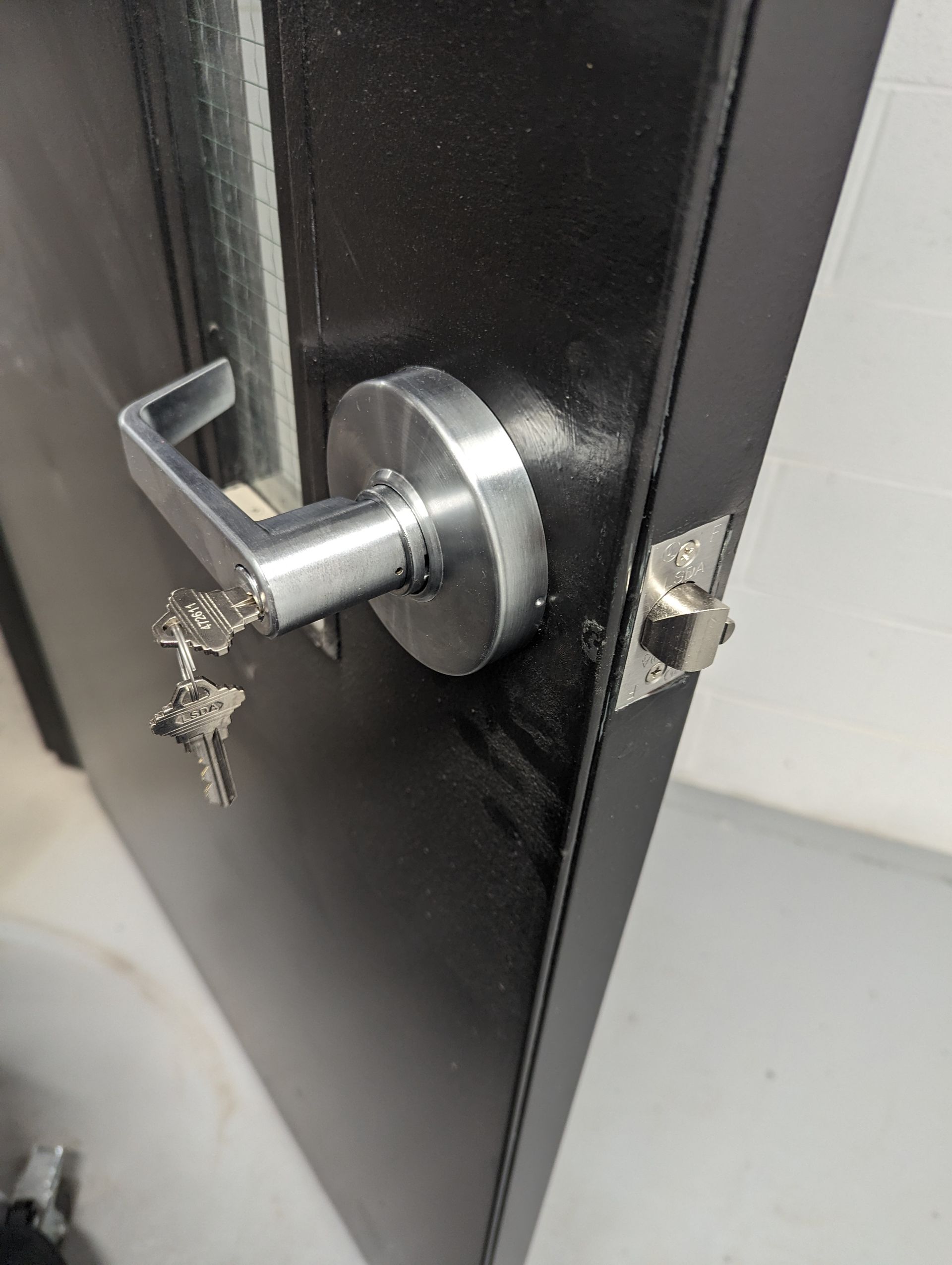A close up of a door with a door handle and keys on it.