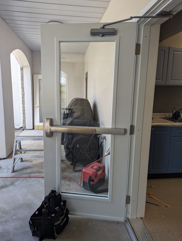 a person is fixing a door handle with a wrench