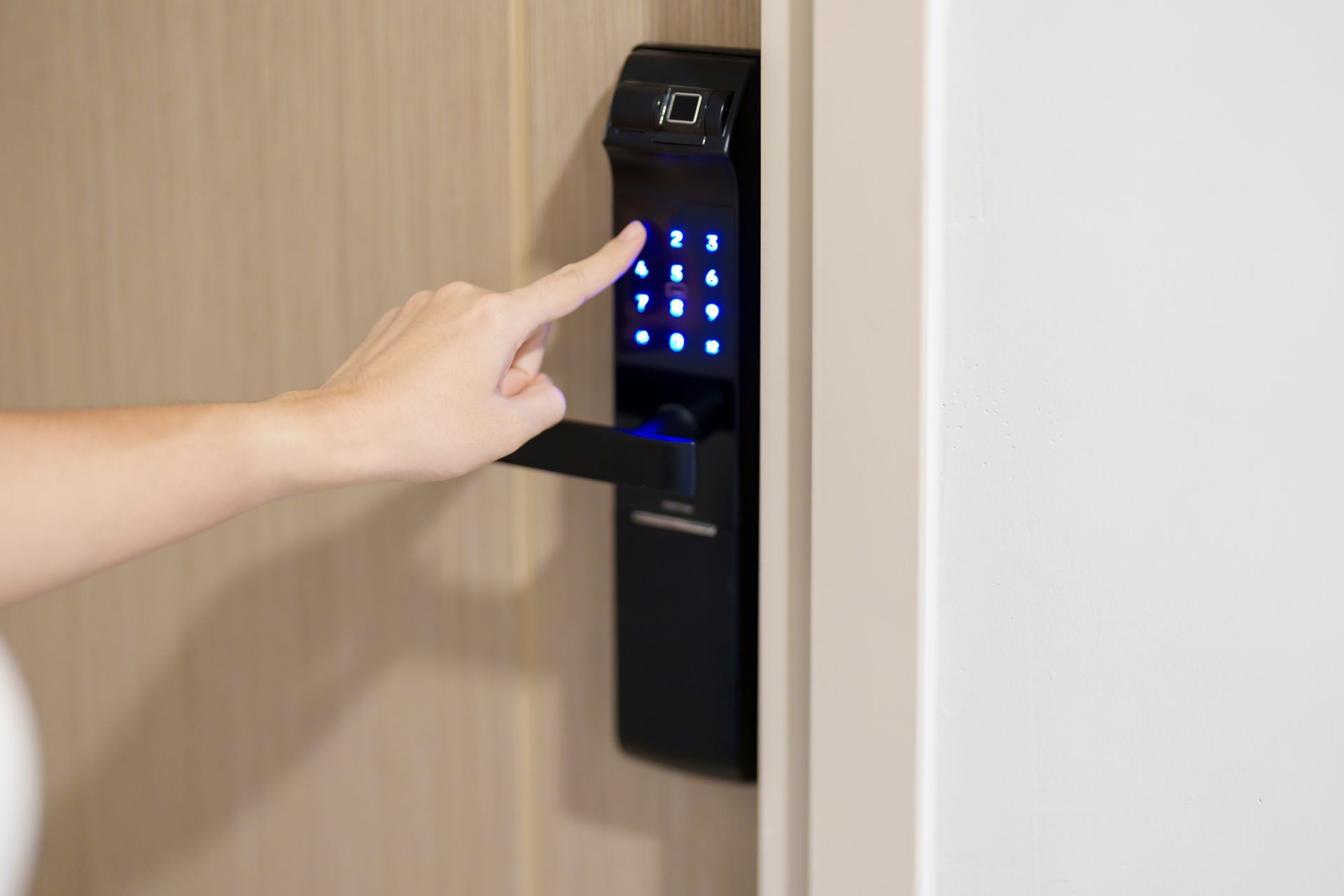 A person is pressing a button on a door lock.