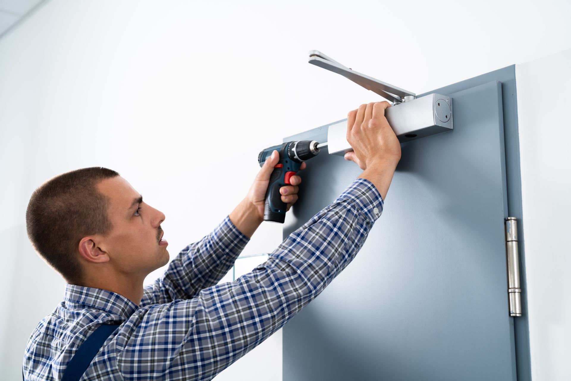 A man is installing a door with a drill.