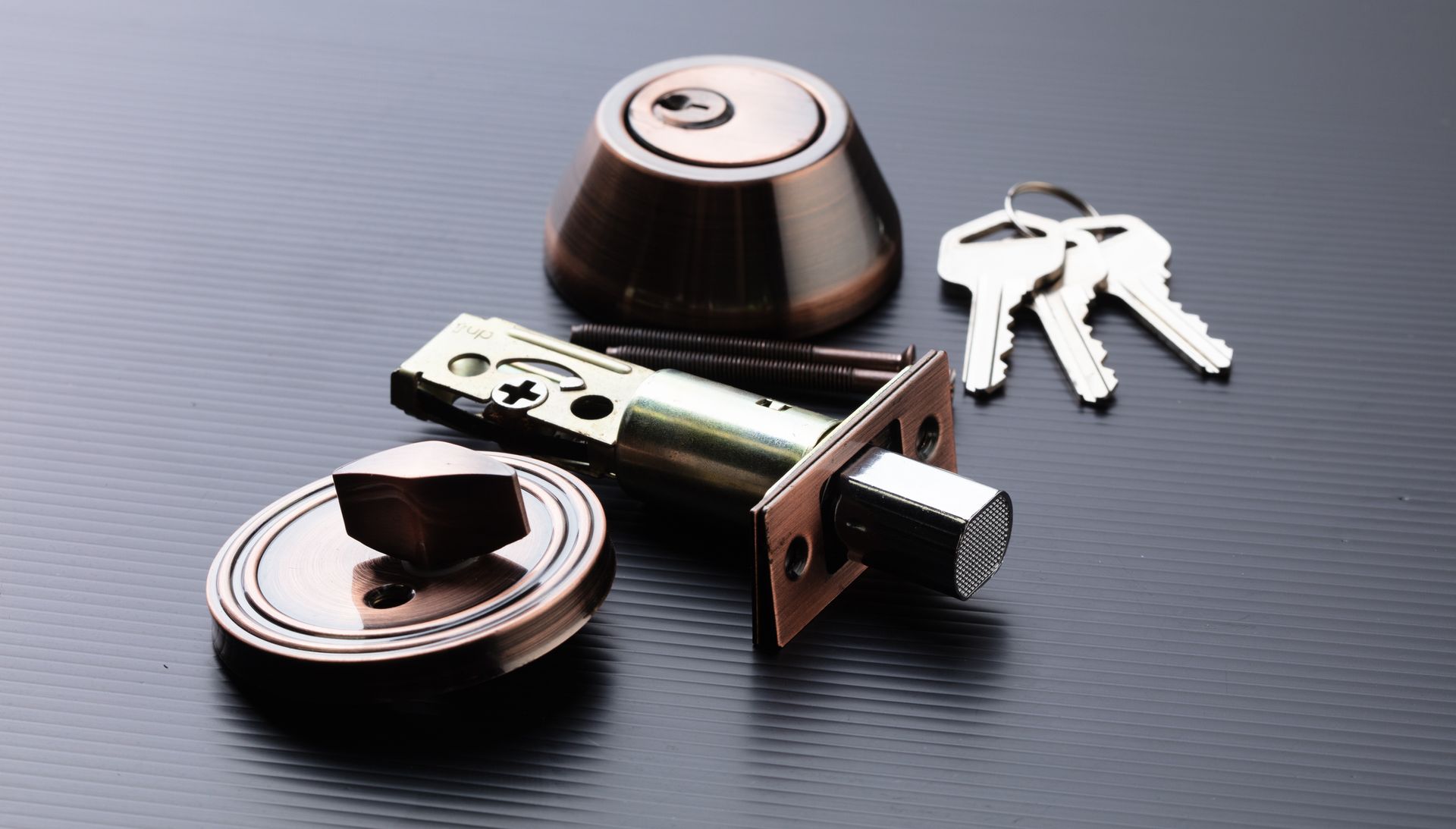 A close up of a door lock with keys on a table