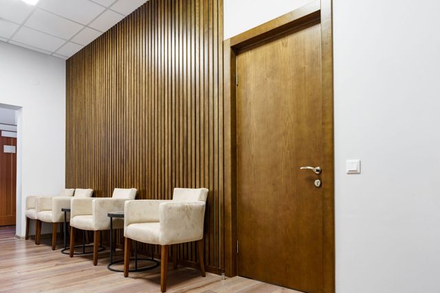 a row of chairs in a waiting room with a wooden wall .