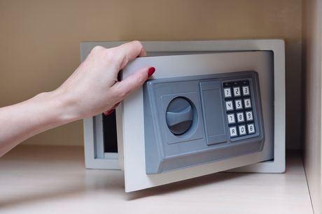 a woman is opening a safe with a keypad .