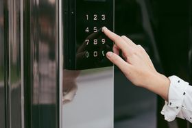 a person is pressing a button on a door with their finger .