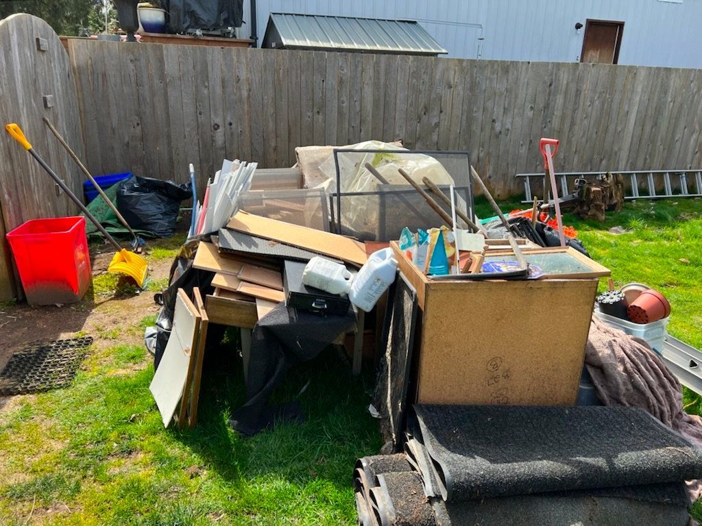 A man wearing a hard hat and goggles is standing in a room.