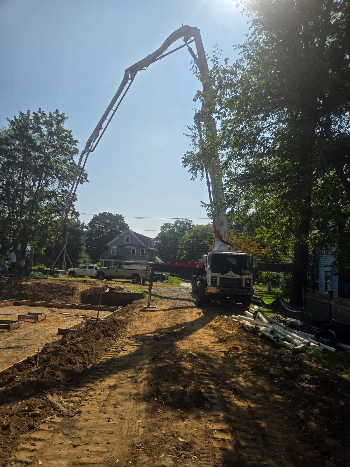 A Crane Is Being Used to Pump Concrete Into a Residential Area - Middletown, CT - American Concrete Pumping