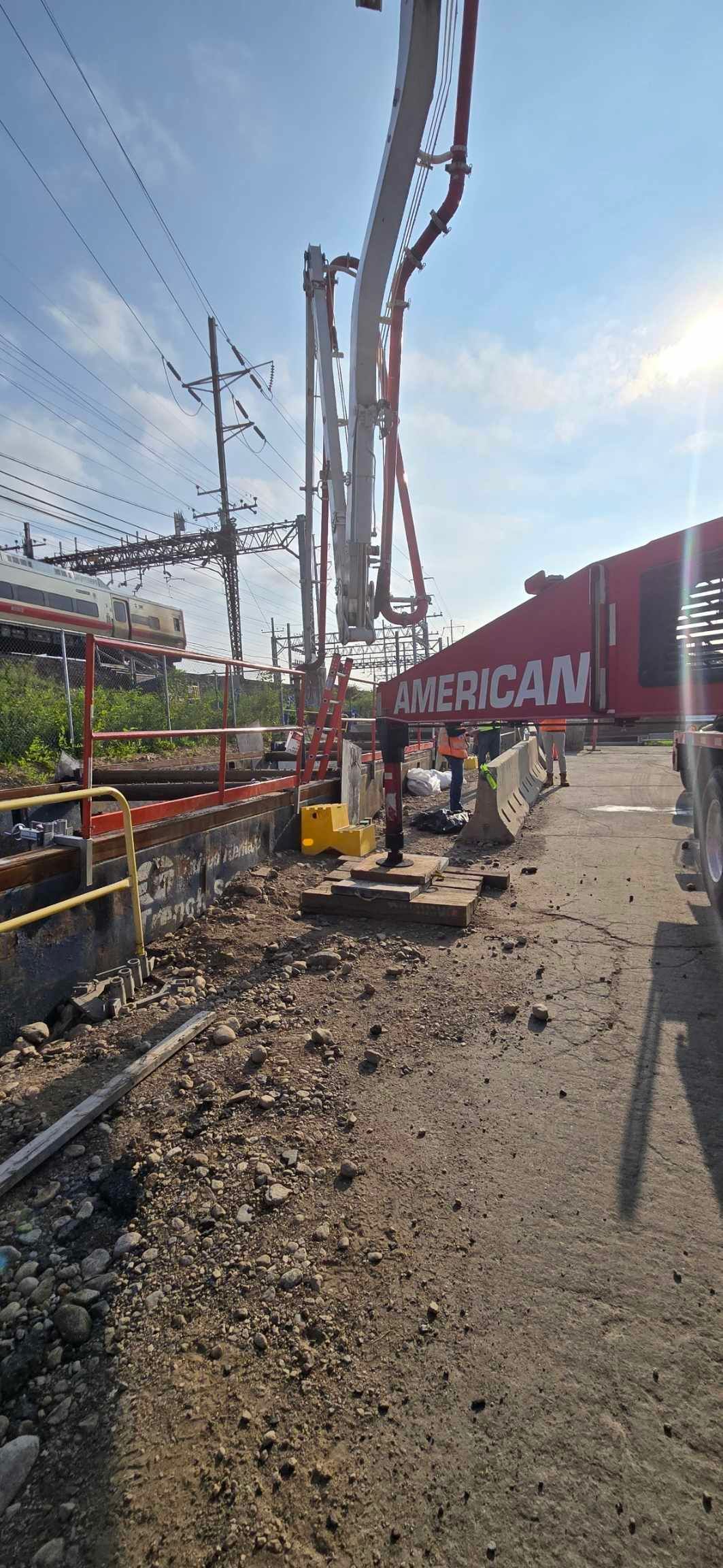 A Construction Worker Is Carrying a Large Pipe of Concrete - Middletown, CT - American Concrete Pumping