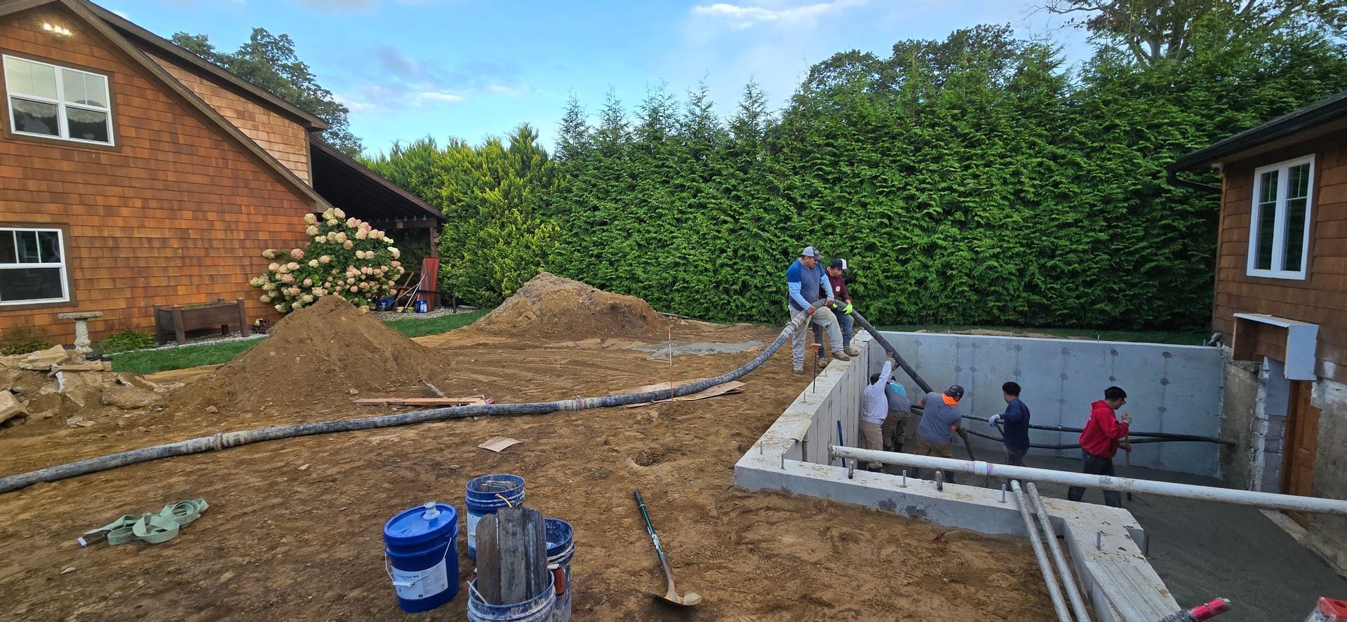 A Person Is Using a Trowel to Spread Concrete on A Sidewalk - Middletown, CT - American Concrete Pumping
