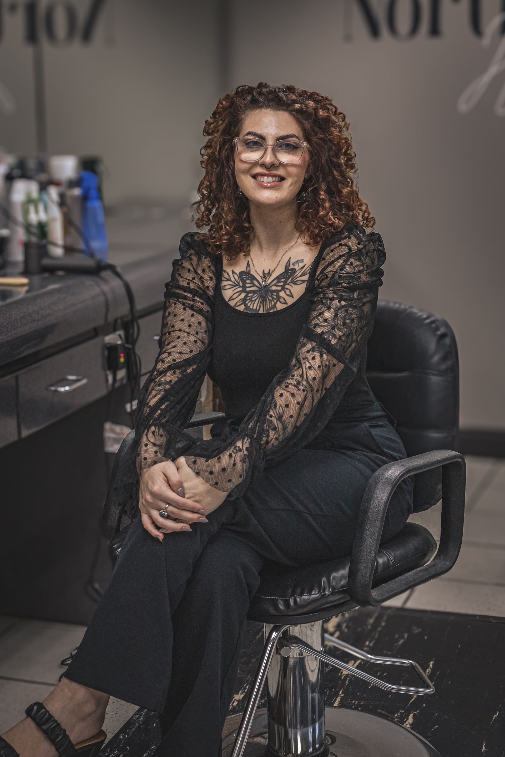 A woman is sitting in a chair in a salon.