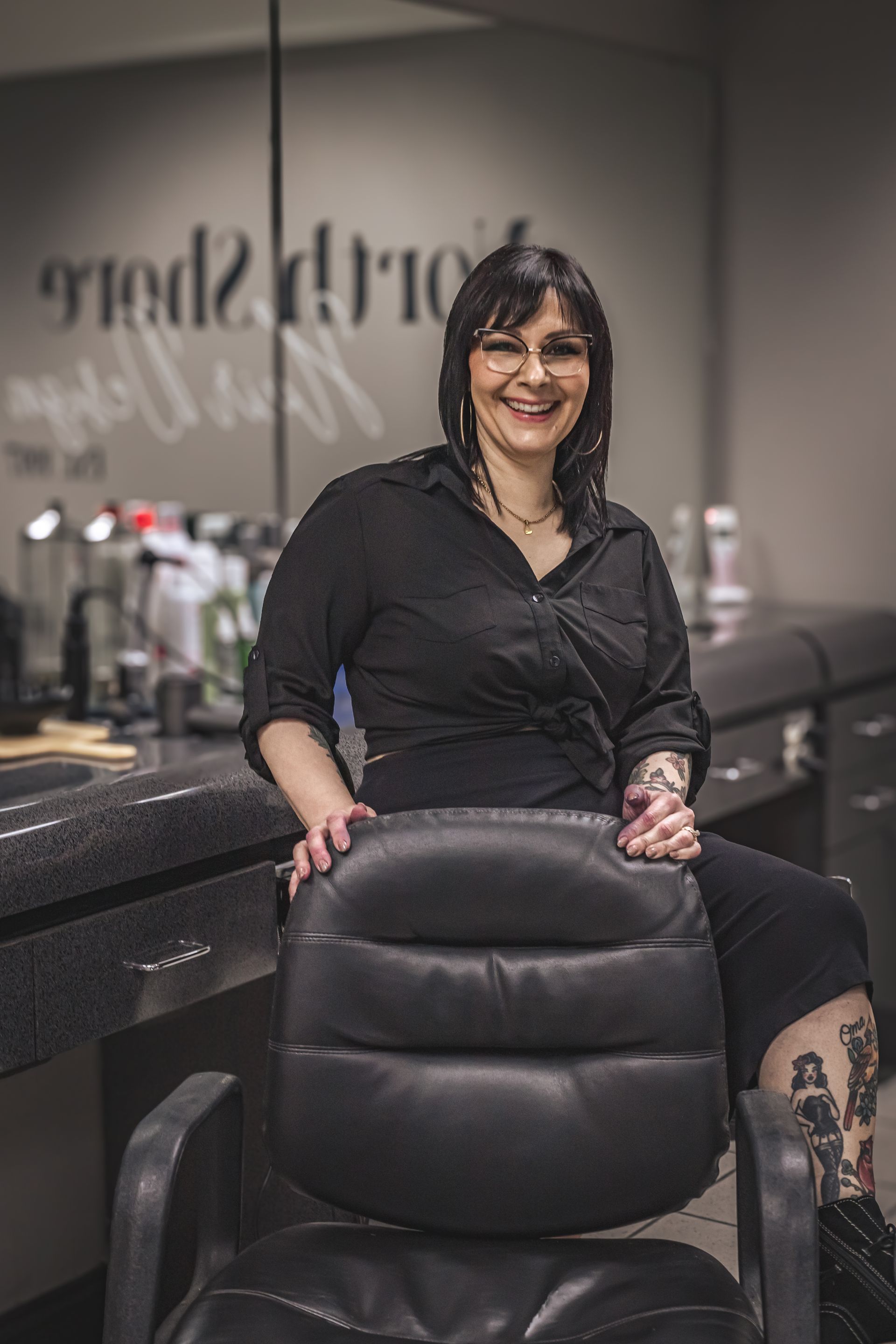 A woman is sitting in a chair in a salon.