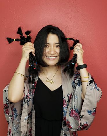 Woman Holding Cut Hair — Washington, WI — North Shore Hair Design Inc