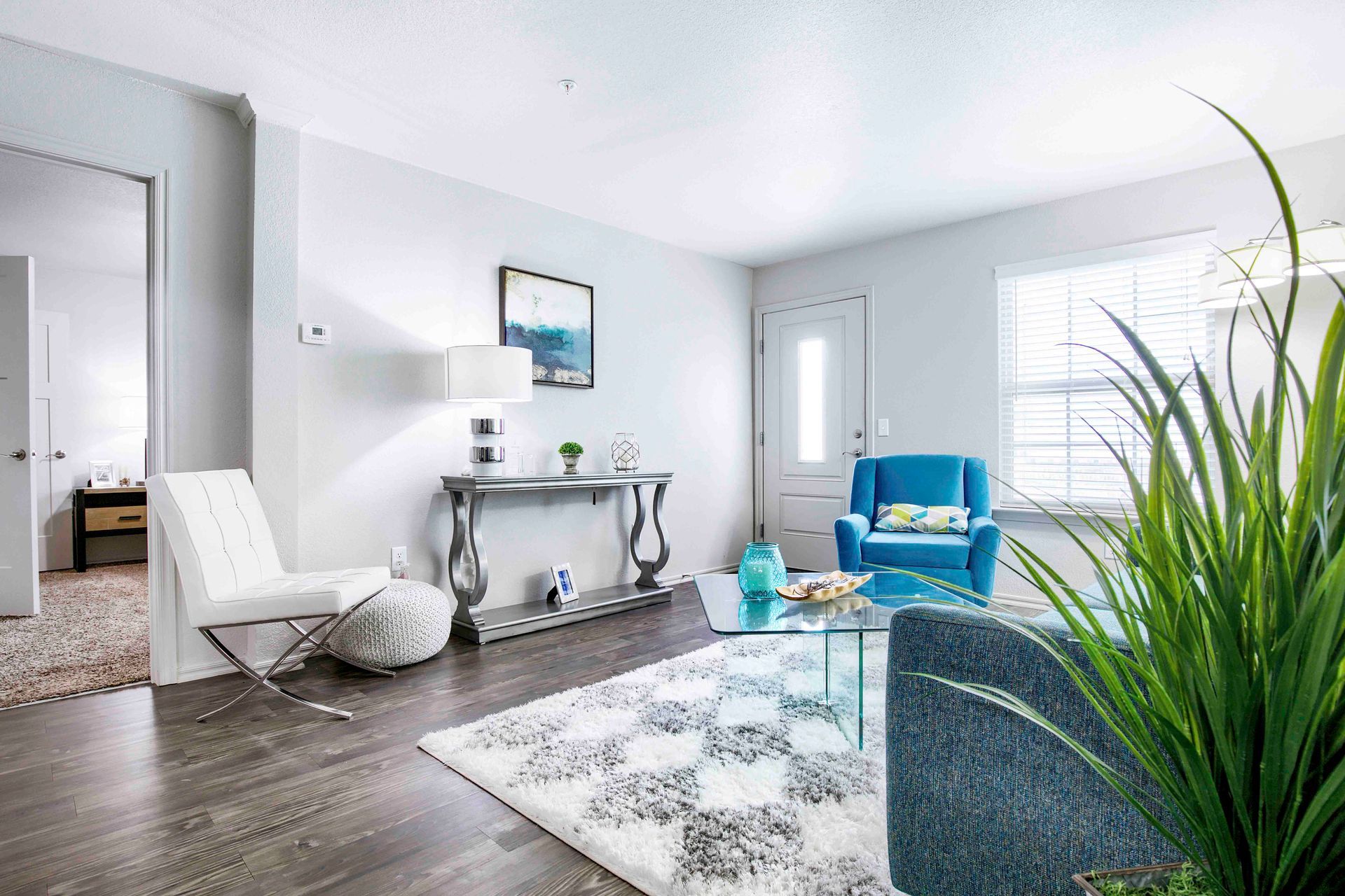 a living room with a blue chair and a white chair