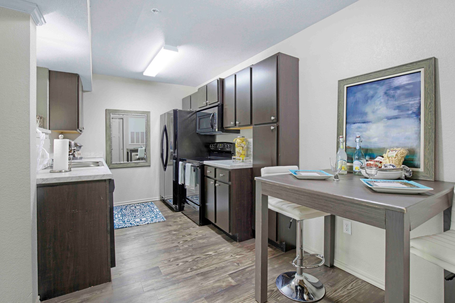 a kitchen with a table and chairs and a painting on the wall