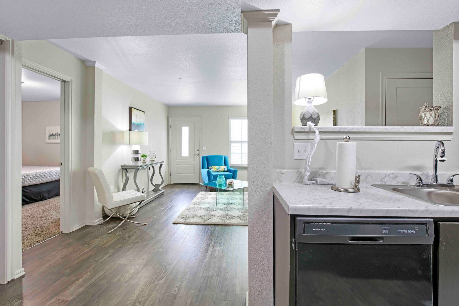 a kitchen with a stainless steel dishwasher and a marble counter top