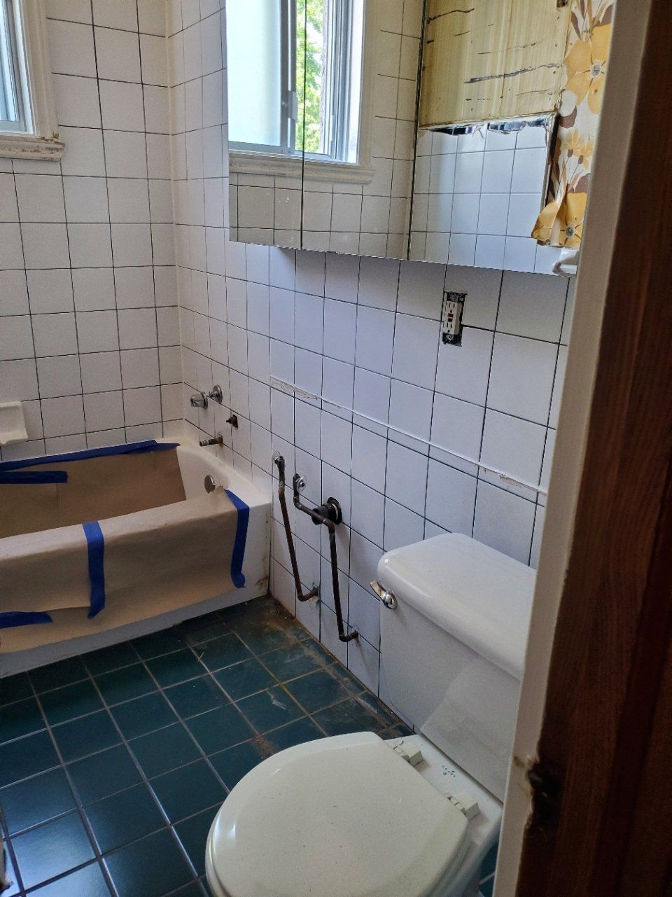 Une salle de bain avec WC, baignoire et miroir.