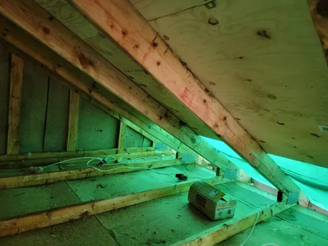 Une bâche verte recouvre le grenier d'une maison en construction.