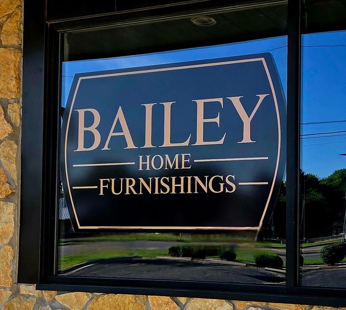 A bailey home furnishings sign is on a window