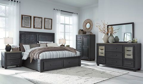 Bedroom set with dark gray furniture, including a bed, nightstands, dresser, chest, and mirror.