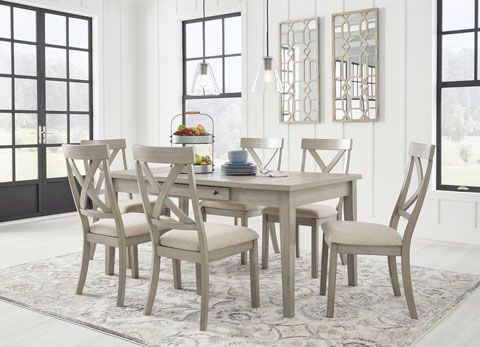 A dining room set with a rectangular table, six chairs, and a rug. The furniture is light gray, and the chairs have a cross-back design.