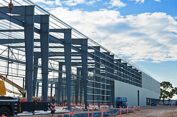 Steel framework of a building under construction against a cloudy sky.