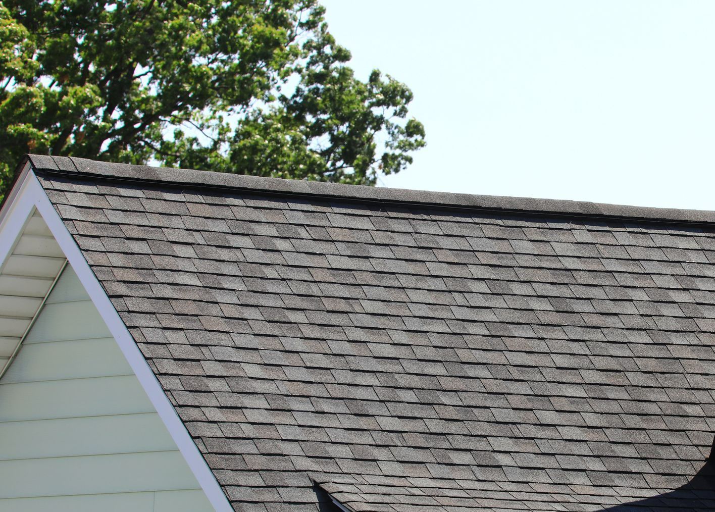 White metal building with green trim, set on grass under a cloudy sky.
