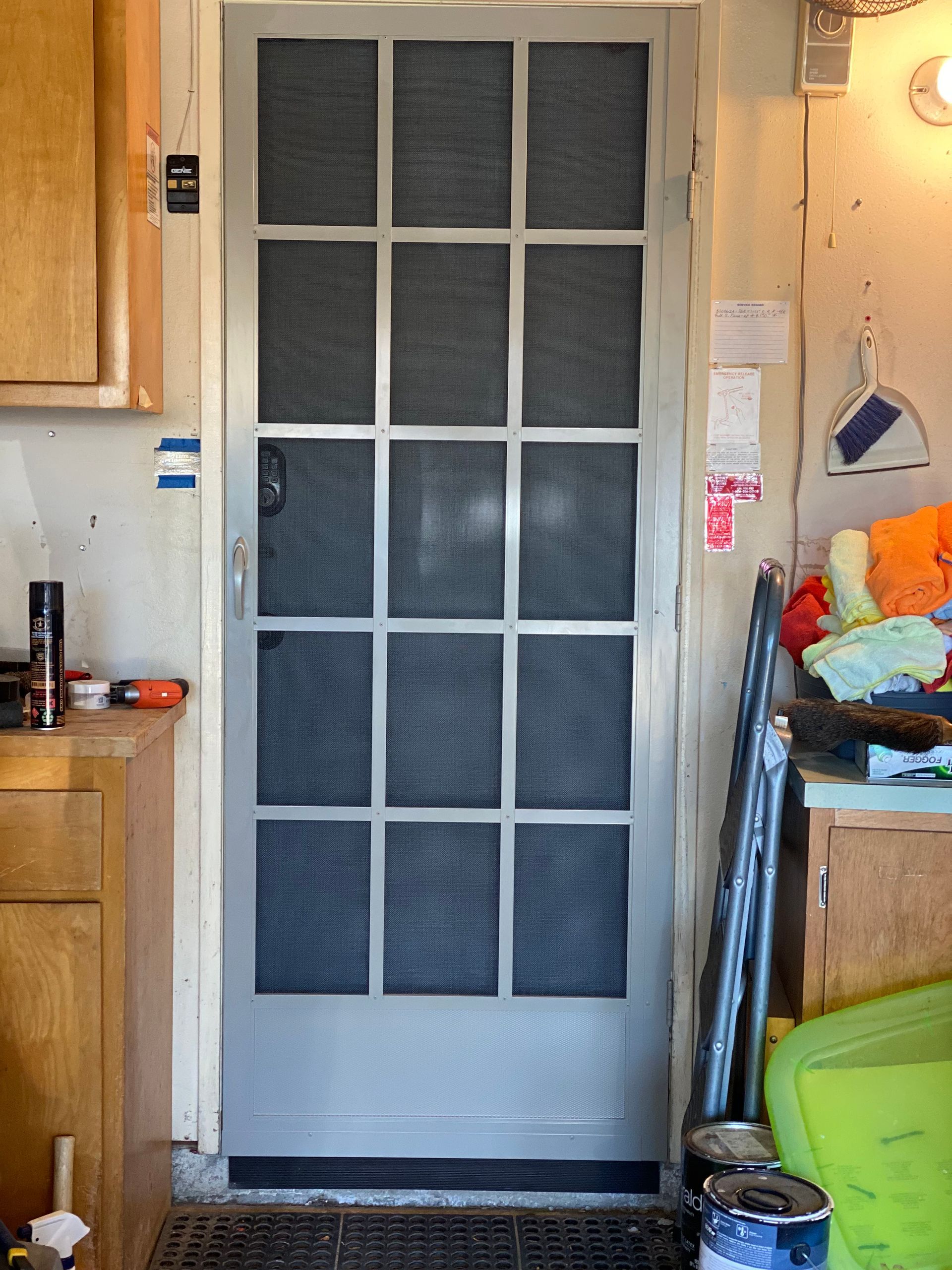 Interior view of a door with a white-framed screen door installed
