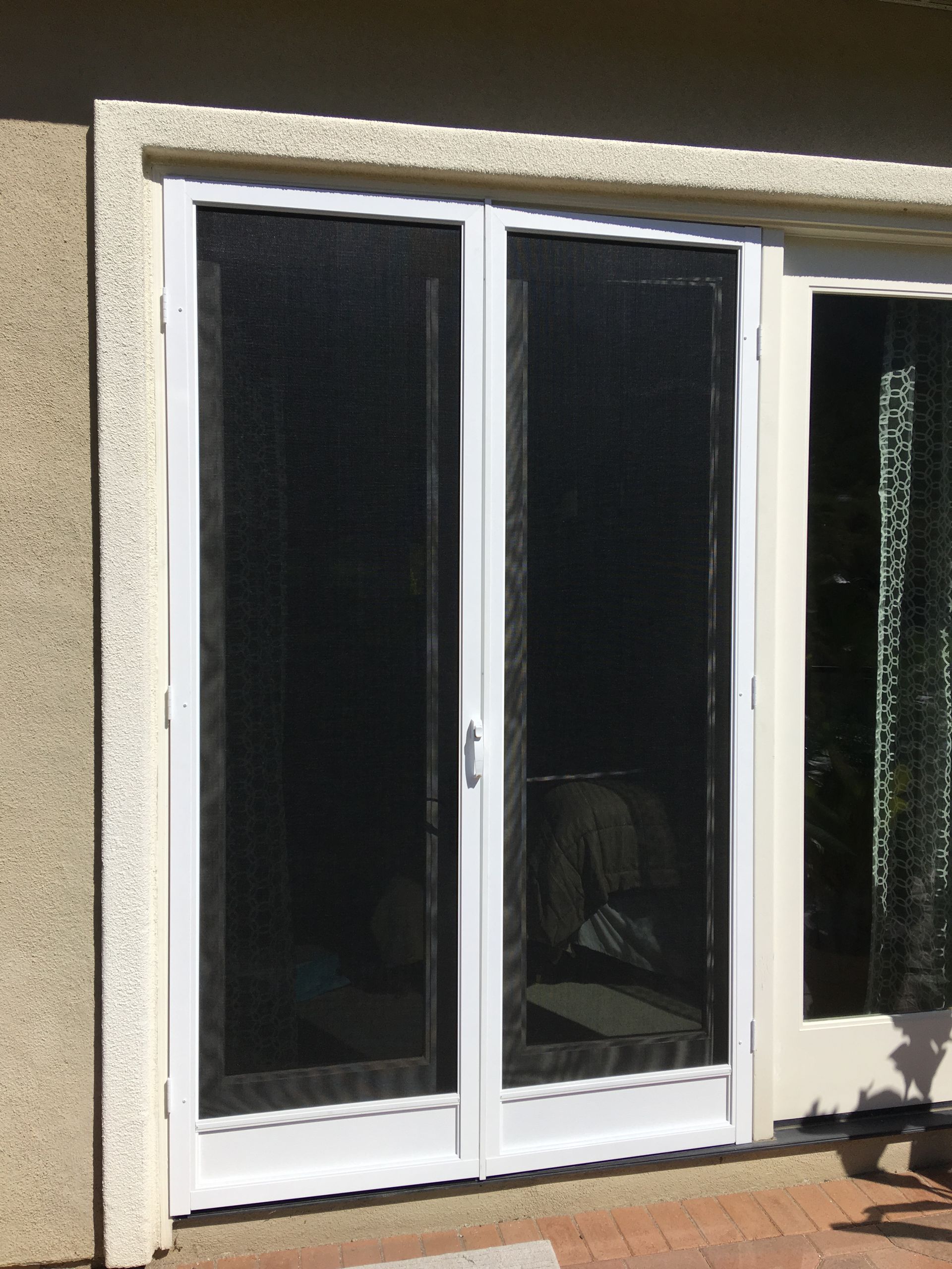 Sliding screened door with a white-framed door installed