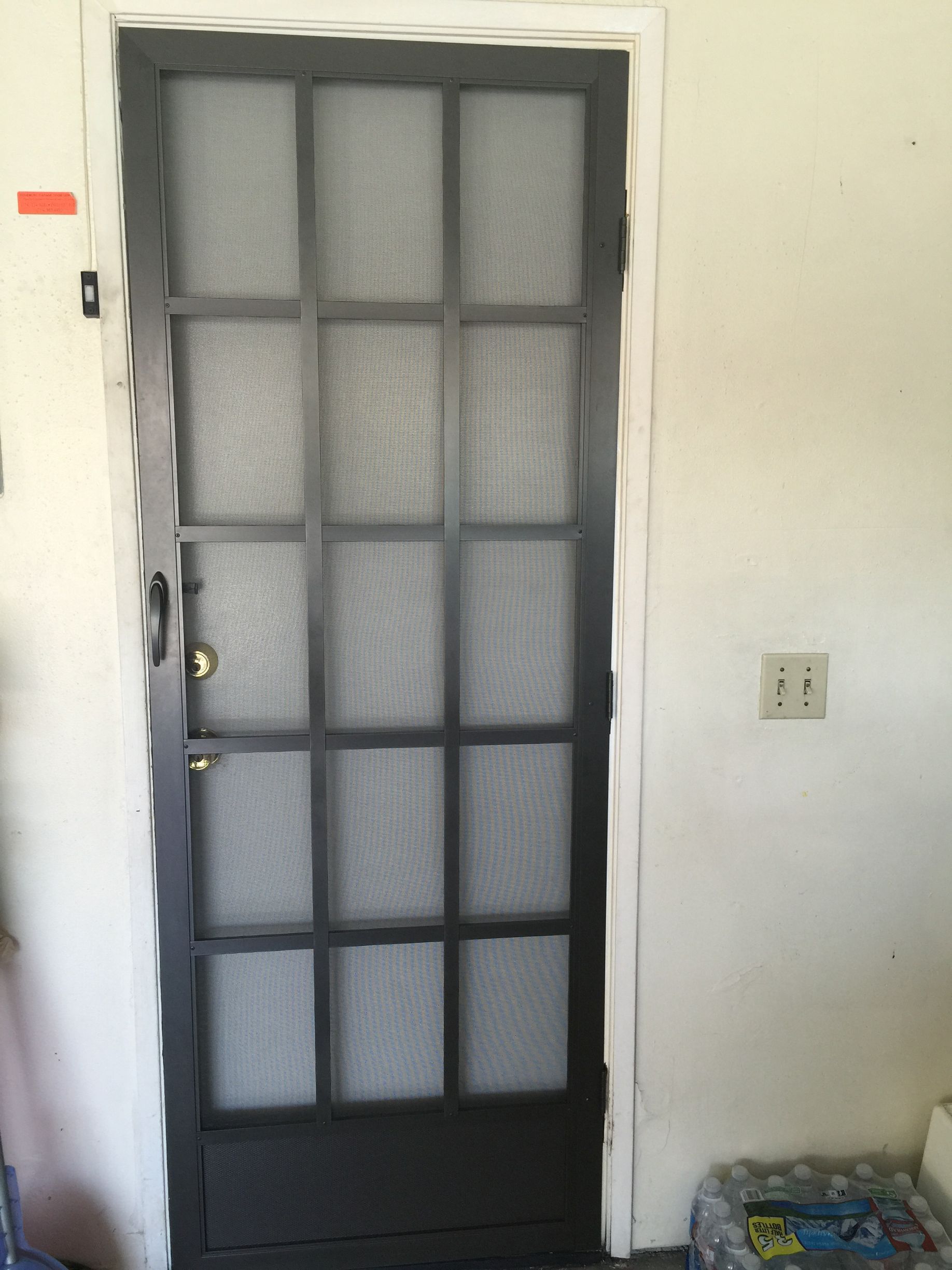 Interior view of a dark-framed screen door with grid design