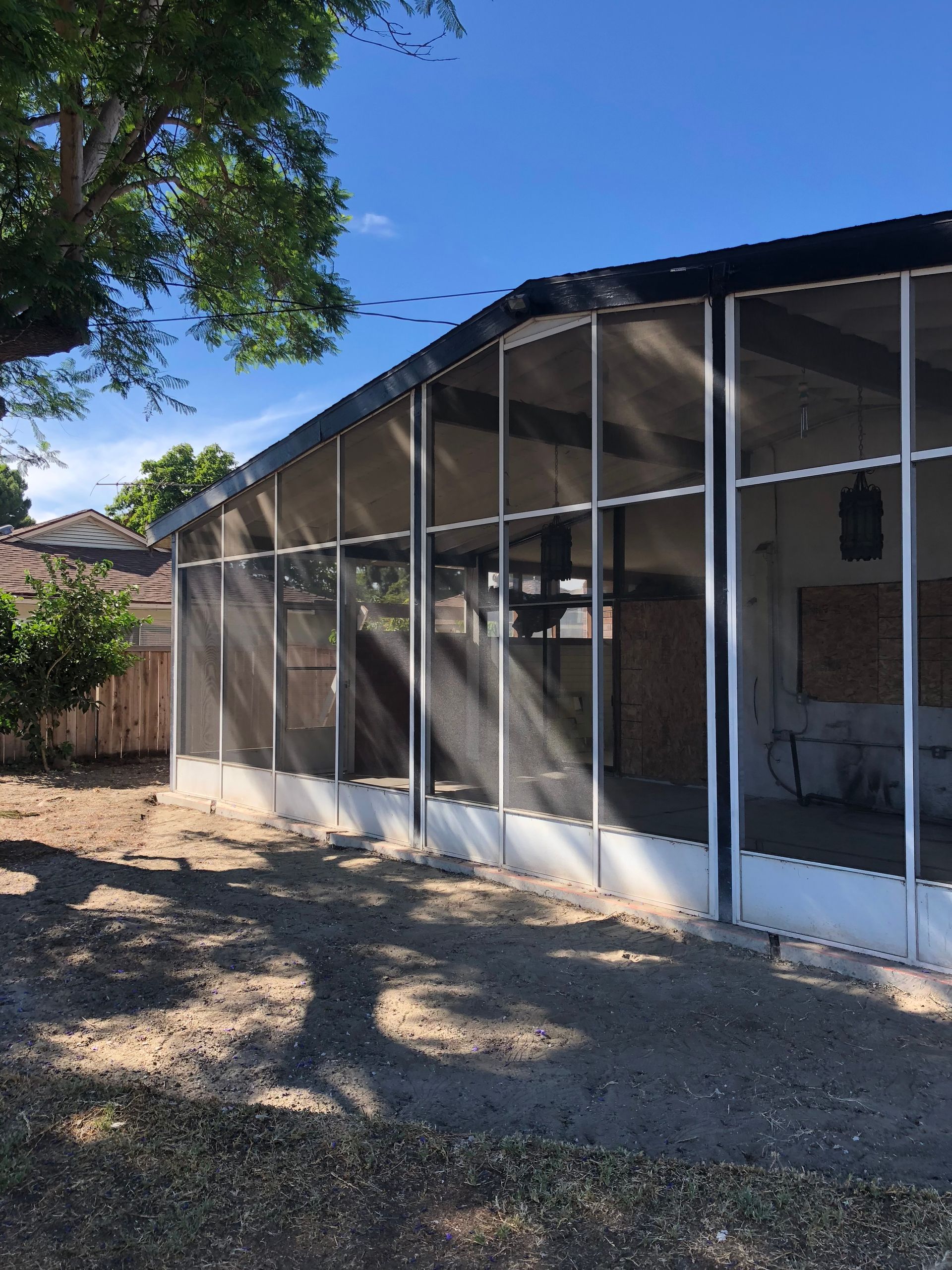 Backyard view of a screened patio enclosure attached to a home