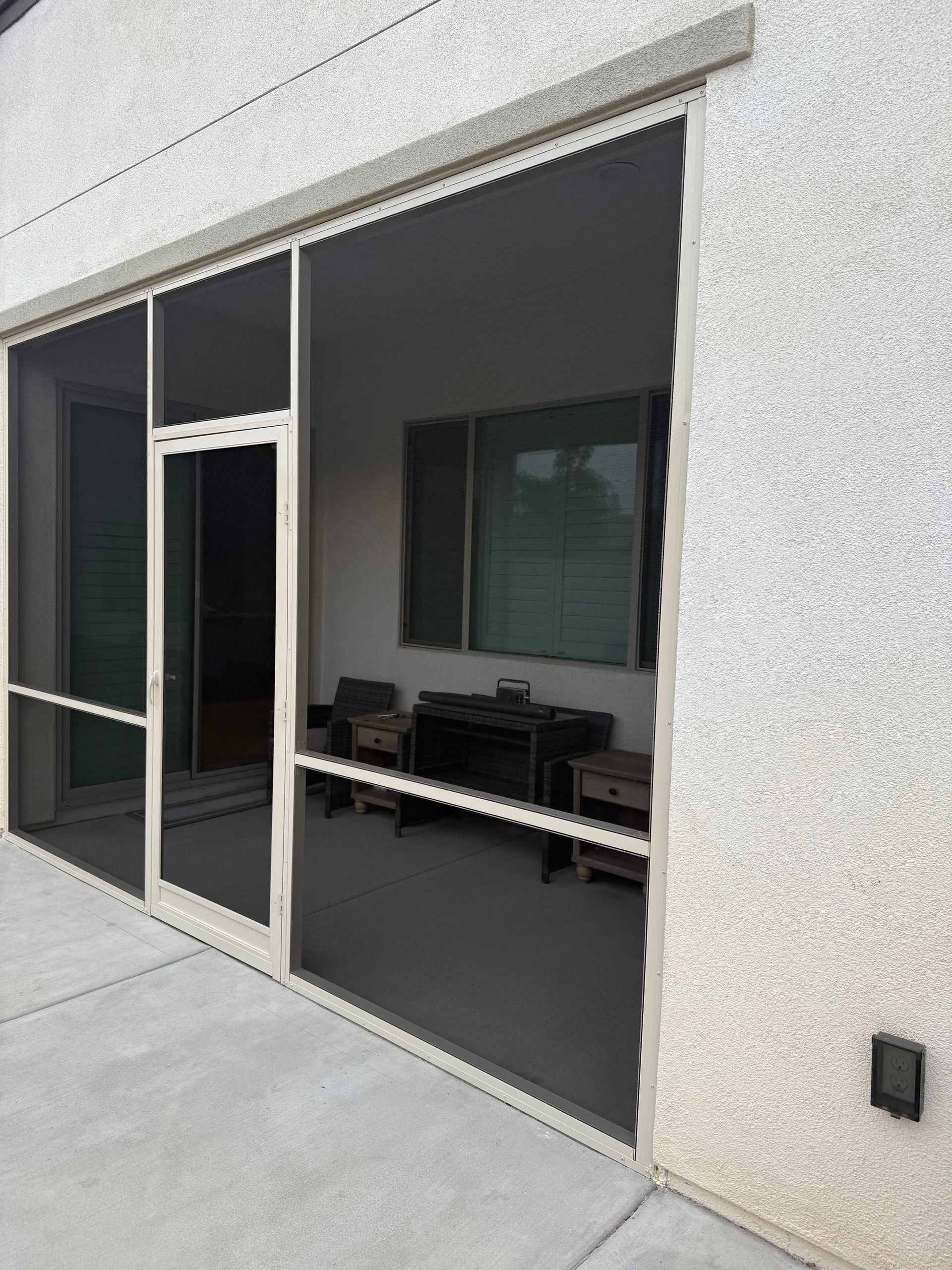 Patio enclosure with sliding screen doors leading into the home