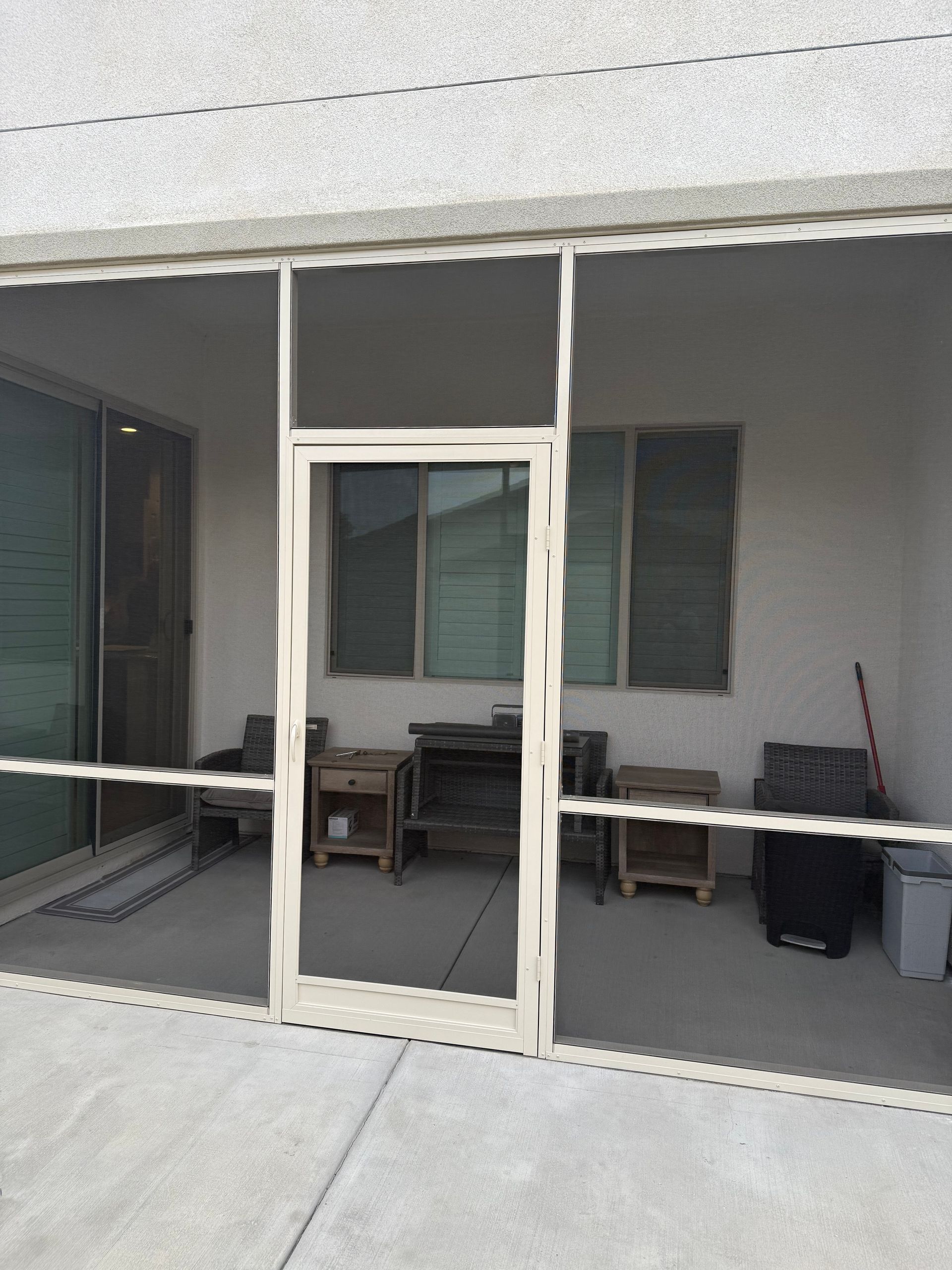 Patio enclosure with sliding screen doors and a covered outdoor area