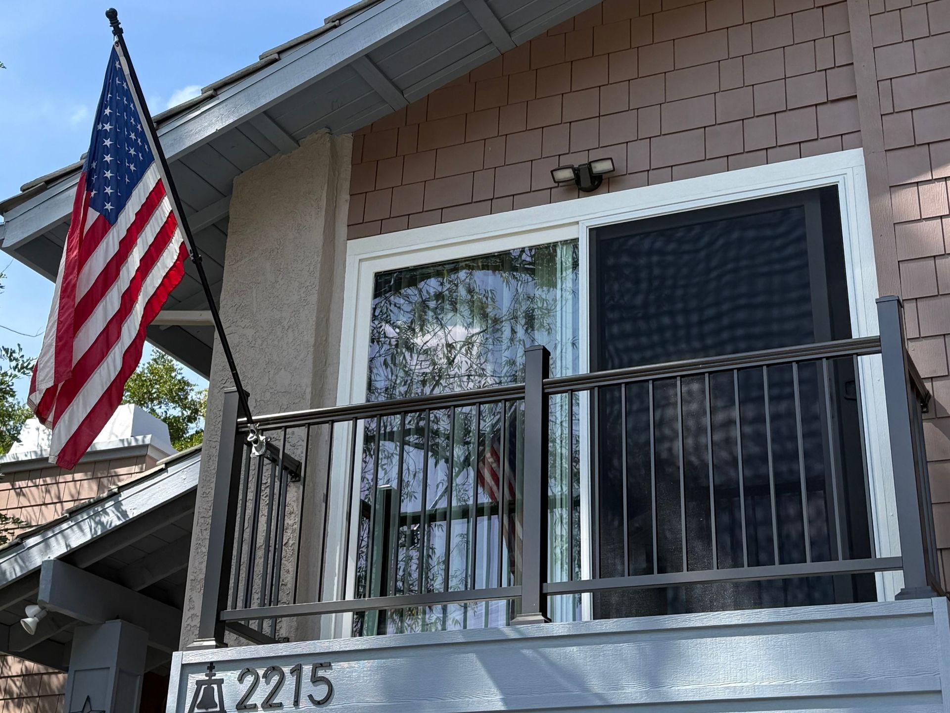 Second-story balcony with a sliding screen door and railing