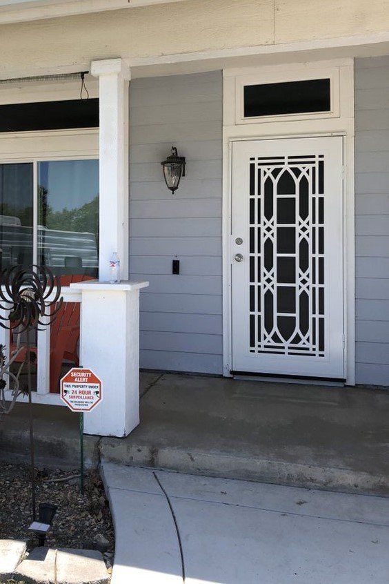 Front entry with a white security screen door and patio area