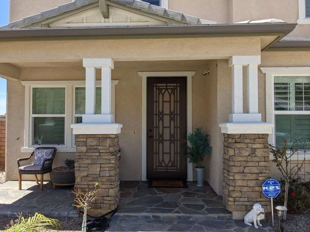 Front porch with columns and screened entry door leading into the home