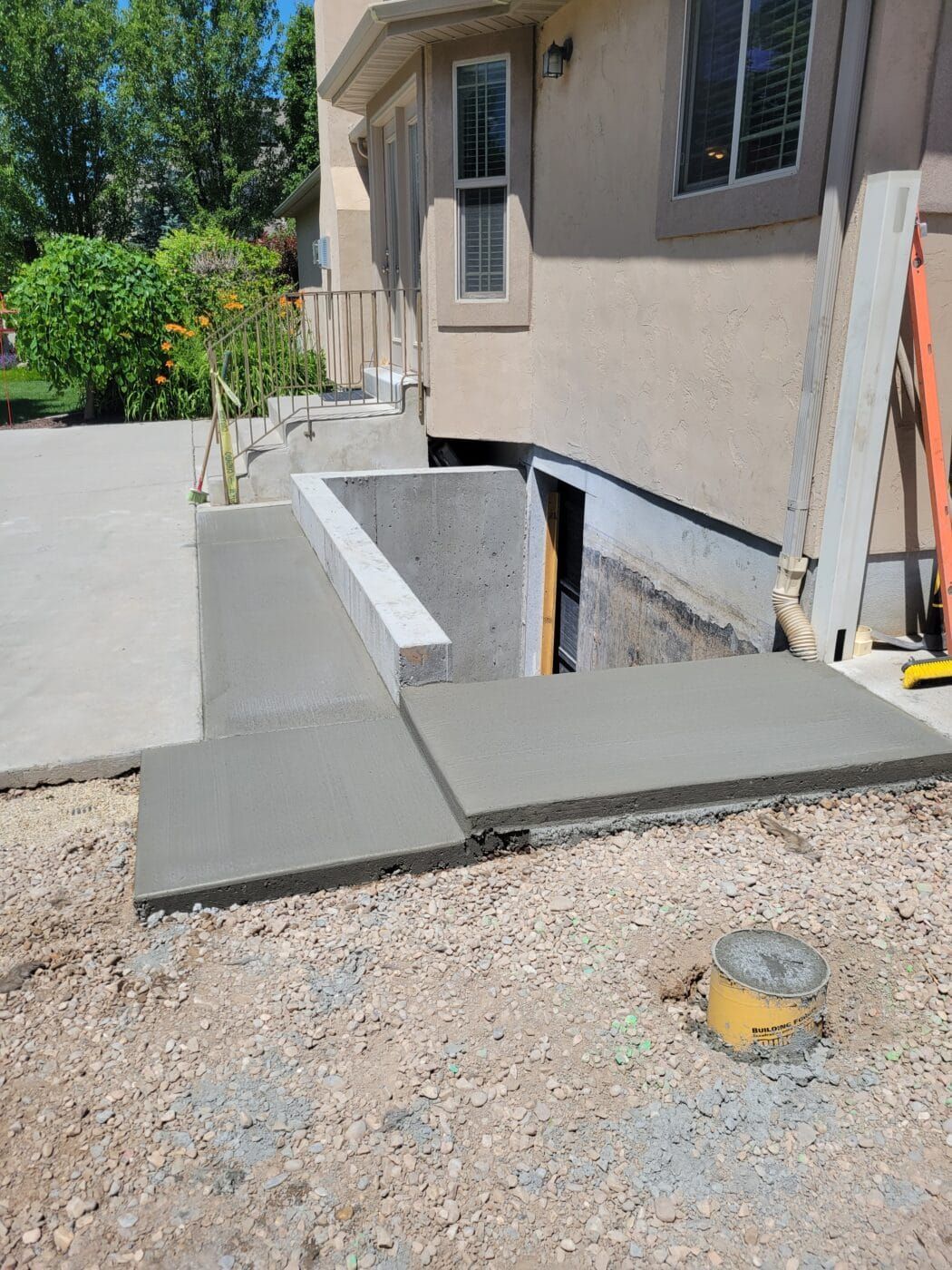 A concrete walkway is being built in front of a house.