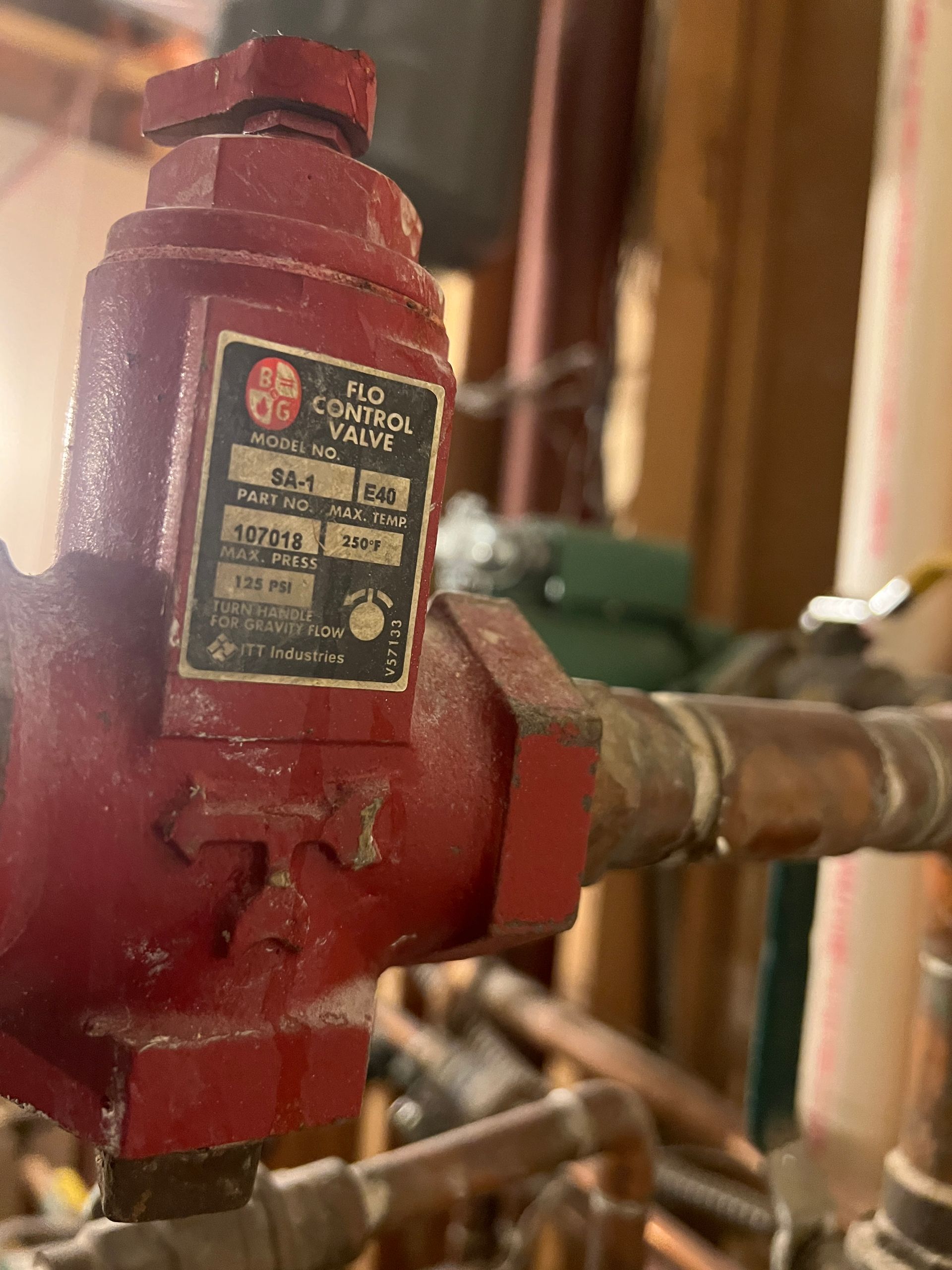 Red Flo Control valve on copper pipes in a utility room.