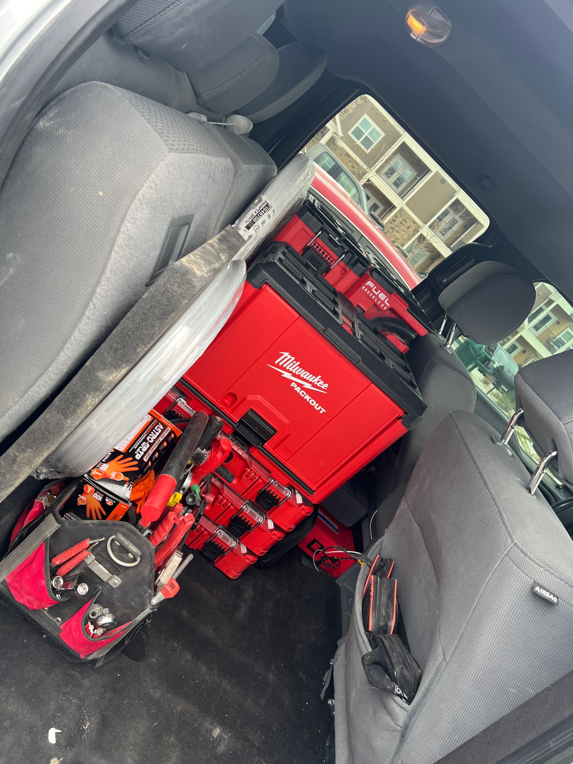 Red toolboxes and tools inside a vehicle.