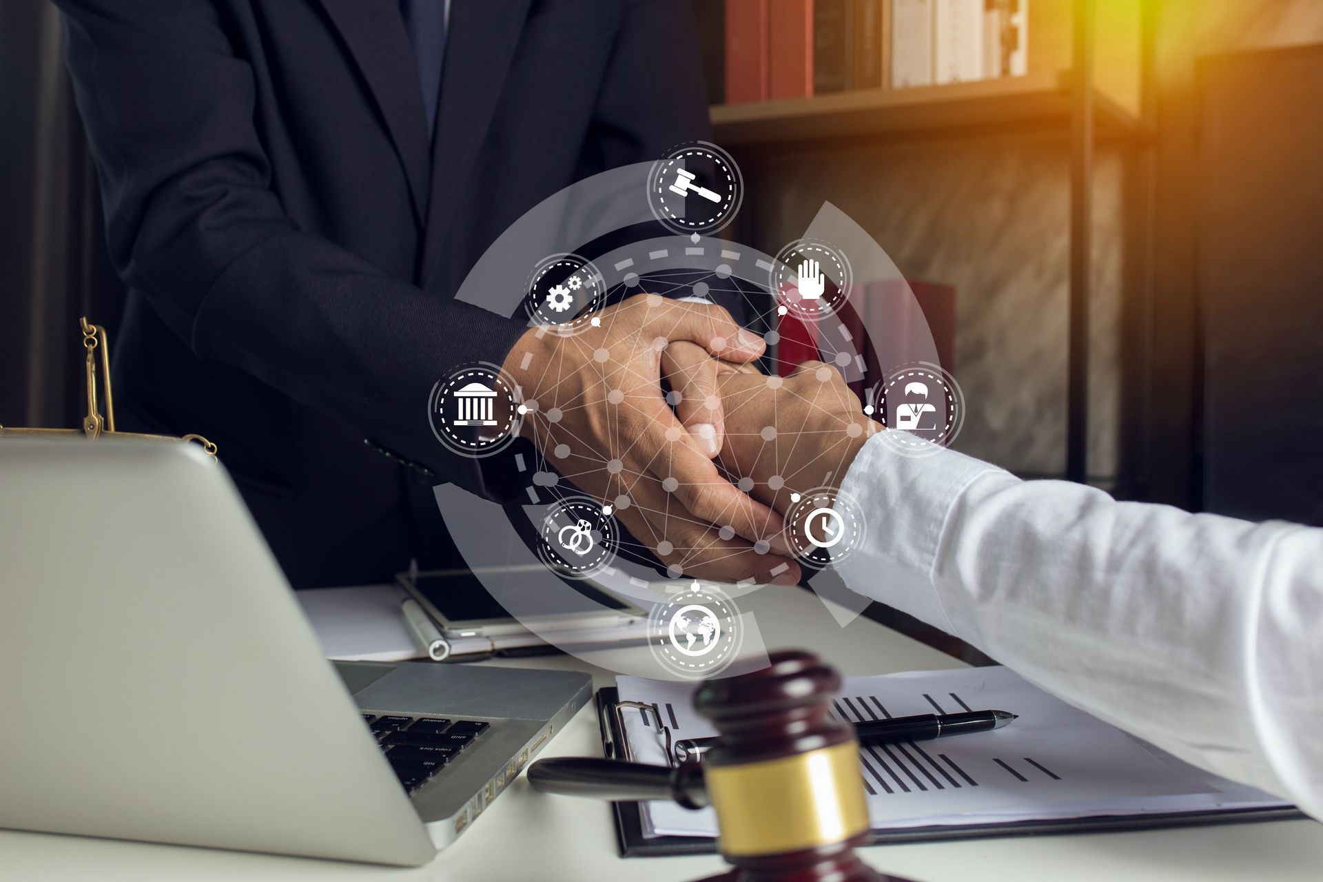 Close-up of a motor vehicle accident lawyer shaking hands with a client during a consultation.
