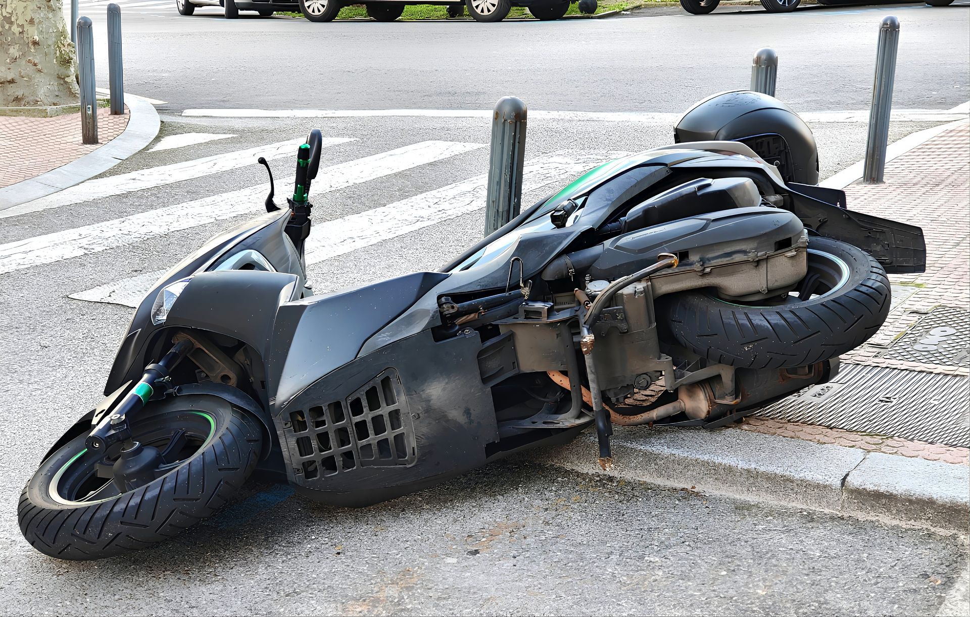 A fallen motorcycle on the sidewalk.